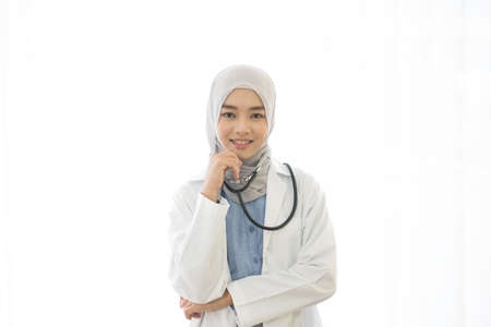 Portrait of Asian muslim female doctor smiling and looking to camera on white backgroundの写真素材