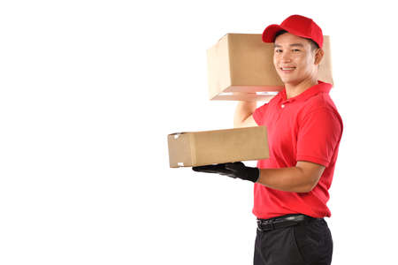 Asian delivery man in red uniform with parcel cardboard box isolated on white backgroundの写真素材