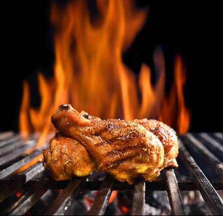 Grilled chicken legs on the flaming grillの写真素材