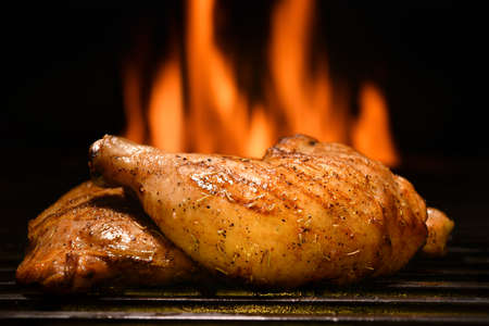Grilled chicken thighs on the flaming grillの写真素材