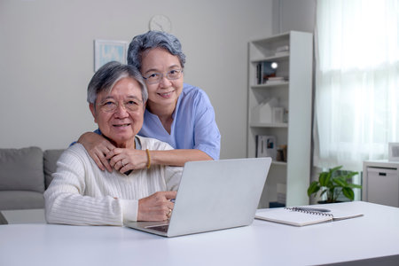Happy Asian Senior couple at home. Handsome old man and attractive old woman are spending time...