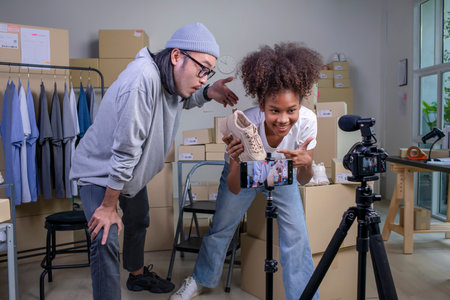 Mixed race couple of Asian man and African-American woman blogger or vlogger looking at camera reviewing product.の写真素材