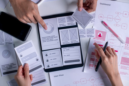 Close up ux developer and ui designer brainstorming about mobile app interface wireframe design on...