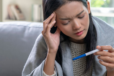 Depressed young Asian woman holding negative or positive pregnancy test.の写真素材