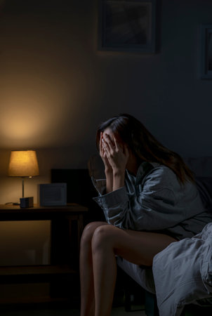 Young Asian woman in bedroom feeling sad tired and worried suffering depression in mental health, woman sitting in bed cannot sleep from insomnia.の写真素材