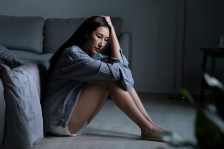 Young Asian woman in bedroom feeling sad tired and worried suffering depression in mental healthの写真素材