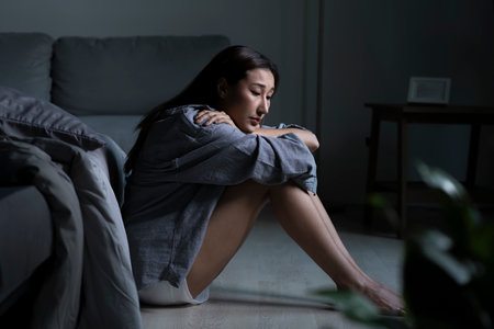 Young Asian woman in bedroom feeling sad tired and worried suffering depression in mental healthの写真素材