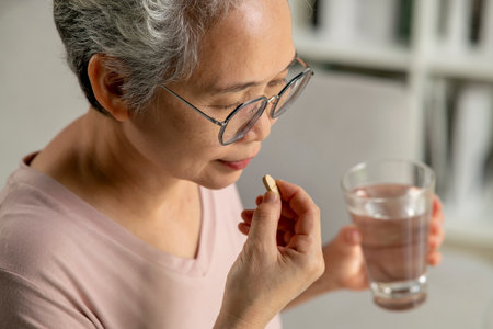 Asian senior woman taking medicine at home, age, medicine, healthcare and people conceptの写真素材