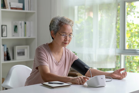 Asian senior woman measuring blood pressure at homeの写真素材
