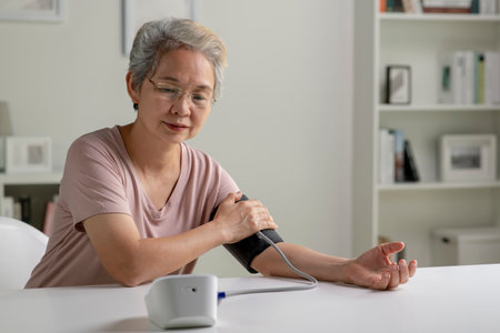 Asian senior woman measuring blood pressure at homeの写真素材