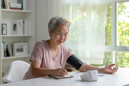 Asian senior woman measuring blood pressure at homeの写真素材