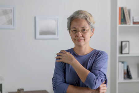 Portrait of healthy Asian senior woman in living room at homeの写真素材