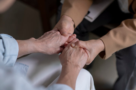 Female therapist, psychologist holding patientâs hands to give support and assuranceの写真素材
