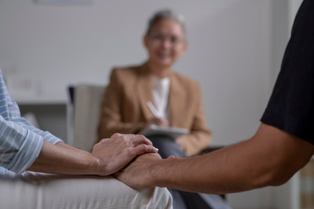Asian couple consulting couple relationship counselling to solve problems. Asian psychiatrist talking to young couple in officeの写真素材