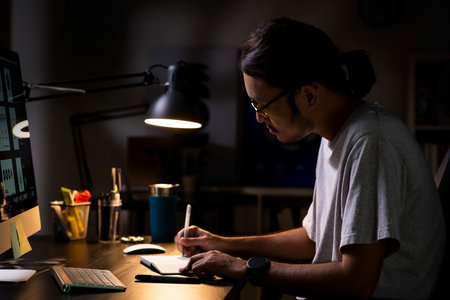 Asian man graphic designer working on computer drawing sketches logo design. The concept of a new brand. Professional creative occupation with idea.の写真素材