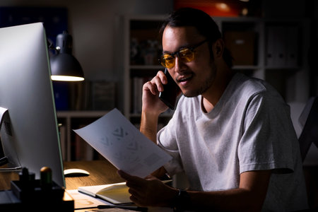 Asian man graphic designer working on computer drawing sketches logo design. The concept of a new brand. Professional creative occupation with idea.の写真素材