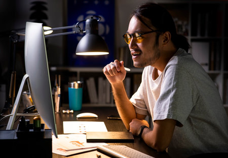 Asian man graphic designer working on computer drawing sketches logo design. The concept of a new brand. Professional creative occupation with idea.の写真素材