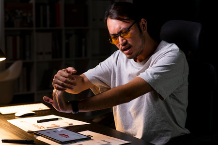 Asian man graphic designer working on computer drawing sketches logo design. Young Asian businessman looking serious and stressed while using laptop to work from home.の写真素材
