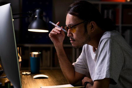Asian man graphic designer working on computer drawing sketches logo design. The concept of a new brand. Professional creative occupation with idea.の写真素材