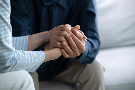 Senior couple holding hands for love, care and trust in home, connection and motivation for mental health.People, comfort and partner for help with kindness, bonding and support for grief.の写真素材