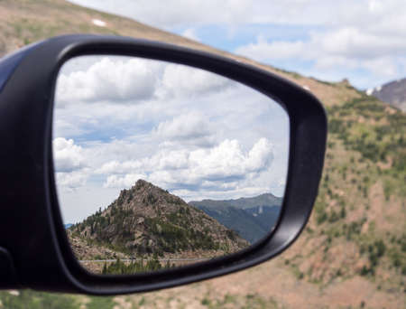 Mountain scenery reflected in car mirror in Rocky Mountain National Parkの写真素材