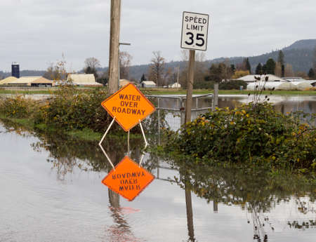 Flooded road with water over roadway signの写真素材