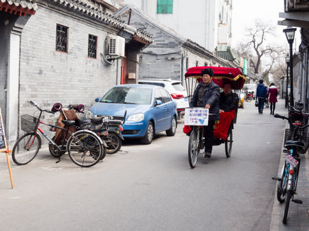Beijing, China - March 8, 2015: Pedicab moving along the narrow lane in historic hutong Sichahai district of Beijingのeditorial素材