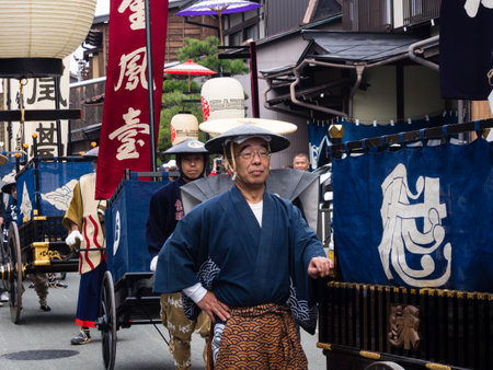 Takayama, Japan - October 10, 2015: Local men in traditional costumes pulling festival carts along the narrow streets of Takayama old town during the annual Takayama Autumn Festival paradeのeditorial素材