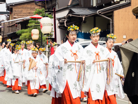 Takayama, Japan - October 10, 2015: Local girls dressed in shinto priestess attire marching the streets of Takayama old town during the annual Takayama Autumn Festival paradeのeditorial素材