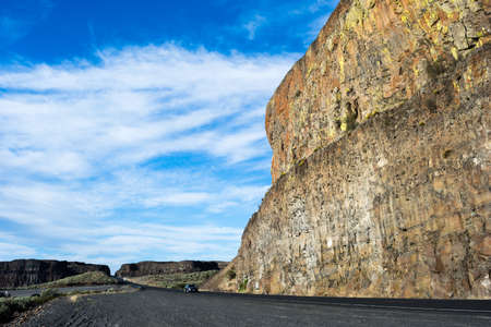 Scenic desert road running along basalt rock formations near Grand Coulee in Eastern Washington state, USAの写真素材