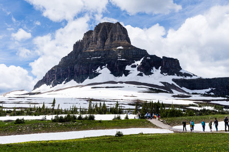 Glacier National Park, USA - July 4, 2016: Hikers walking along Hidden Lake trail with Clements mountain on the backgroundのeditorial素材
