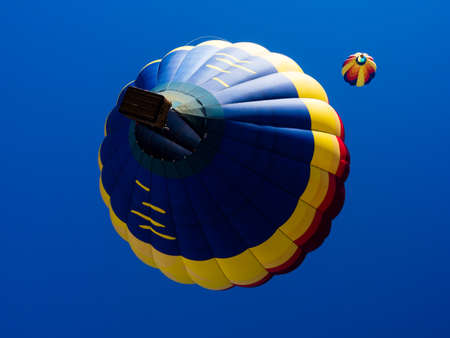 Colorful hot air balloons flying in the bright blue sky during Winthrop Balloon Festival in Washington stateの写真素材