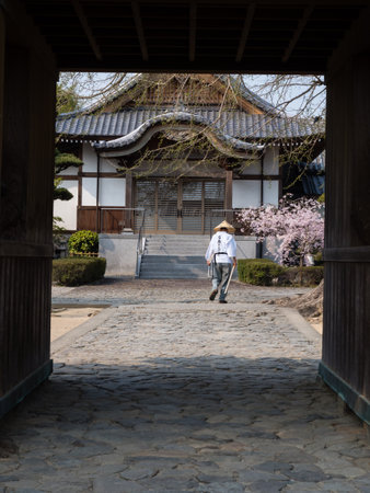 Tokushima, Japan - April 2, 2018: Walking pilgrim at the entrance to Jizoji, temple number 5 on Shikoku pilgrimage