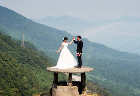 Thua Thien Hue province, Vietnam - March 13, 2016: Asian couple posing for wedding photos at the top of scenic Hai Van passのeditorial素材