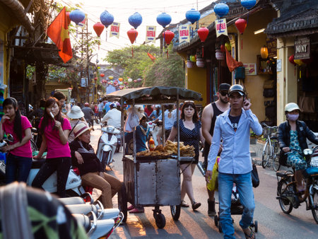Hoi An, Vietnam - March 13, 2016: Busy old town street crowded with tourists and vendors in the eveningのeditorial素材