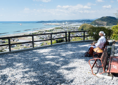 Kochi, Japan - April 7, 2018: Pilgrim taking a break and admiring the view of Kochi coastline at Zenjibuji, temple number 32 of Shikoku pilgrimageのeditorial素材