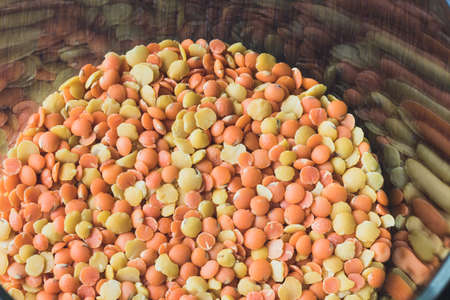 Glass pot full of red and yellow lentils