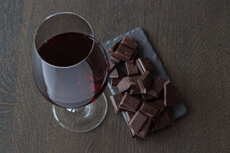 Red wine and chocolates on a wooden tableの写真素材