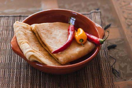 Bowl with Naan and peppers on rustic tableの写真素材