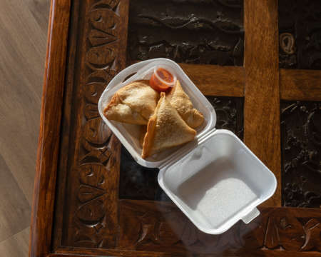 Samosa take away at a rustic table top