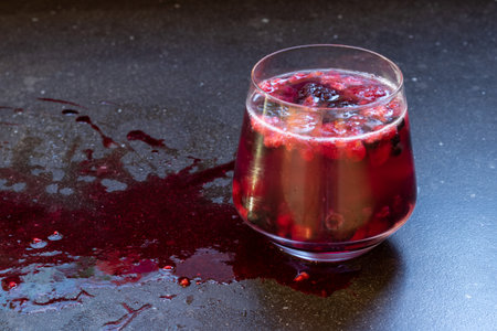Red berries juice with red splash on a dark background, halloween drinkの写真素材