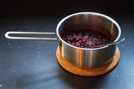 making cranberry sauce at home holding the panの写真素材