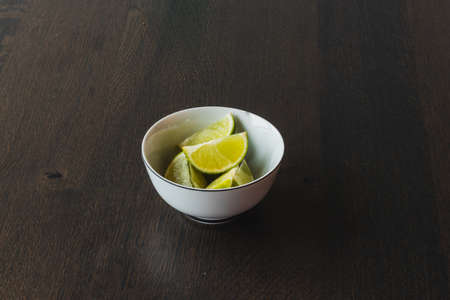 Lime wedges inside of a white bowlの写真素材