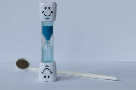 hourglass with smile and colored sand pouringの写真素材