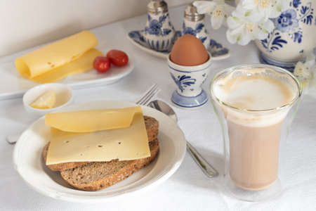Breakfast table with bread, coffee, cheese, egg, jamの写真素材