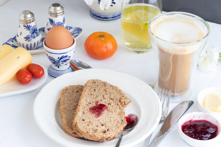 Breakfast table with bread, coffee, cheese, egg, jamの写真素材