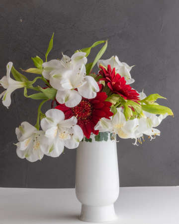 White porcelain vase with red and white flowersの写真素材