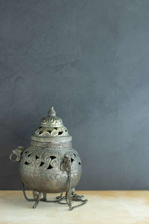 Antique metal incense burner on gray backgroundの写真素材