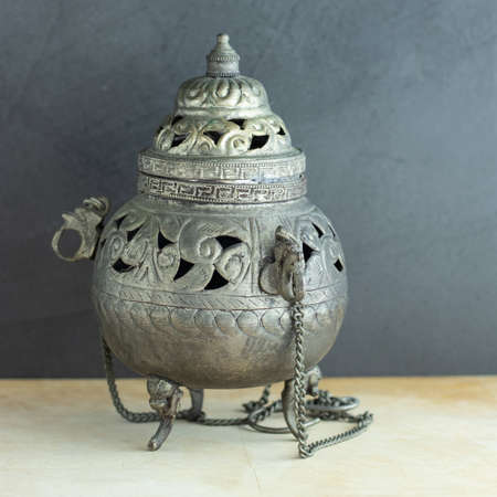 Antique metal incense burner on gray backgroundの写真素材