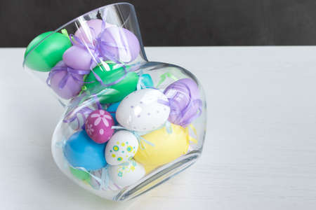 Glass vase filled with colorful Easter eggsの写真素材